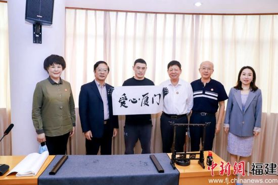 殘障人士代表現(xiàn)場書寫毛筆字“愛心廈門”。