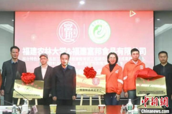 在閩臺商吳妘蓁(左三)的企業(yè)與福建農(nóng)林大學共建科研成果轉(zhuǎn)化基地?！「话钍称饭﹫D