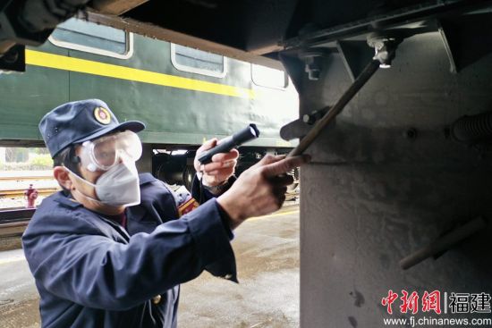 2.發(fā)電車乘務(wù)員在列車整備庫內(nèi)，敲擊檢查車下電池箱固定螺栓，保證緊固安全。王玉星 攝