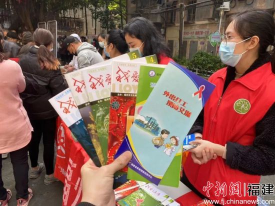 巾幗志愿者向社區(qū)居民發(fā)放宣傳手冊(cè)。