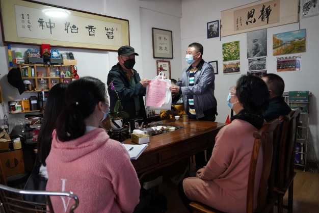 圖為志愿者們給澳門同胞李先生送上防疫用品。1.png