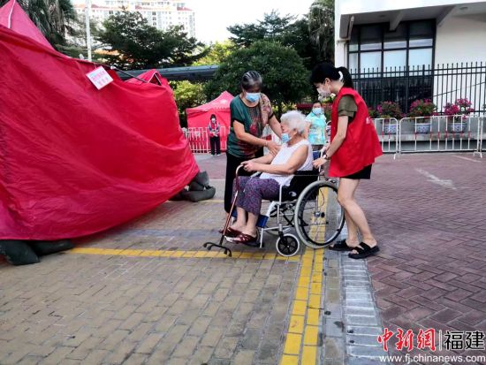 志愿者幫助行動不便的老人。陳向輝 攝