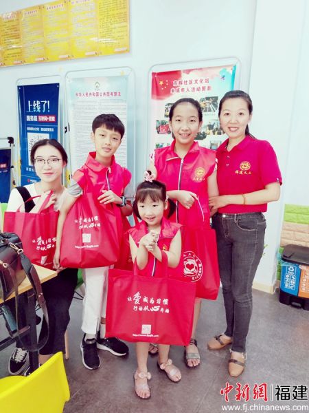 圖為陳霞（右一）帶著大女兒（右二）和小女兒（右三）一起去社區(qū)慰問困難群眾。受訪者 供圖