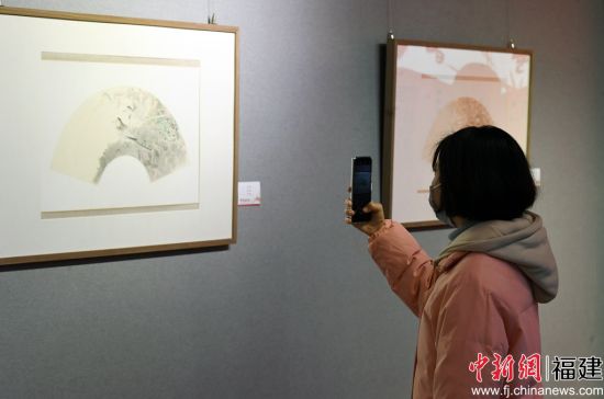 一名女青年用手機(jī)拍攝參展作品。記者 劉可耕 攝