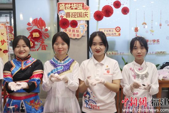 圖為少數(shù)民族學生包月餅共度中秋佳節(jié)。