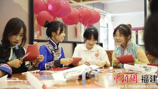 圖為少數(shù)民族學生包月餅共度中秋佳節(jié)。