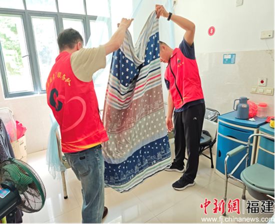 圖為退役軍人高偉彬等在房間內(nèi)幫忙整理被褥。謝丹供圖。